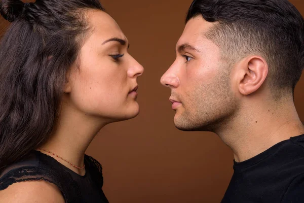 Jovem casal juntos e no amor contra fundo marrom — Fotografia de Stock