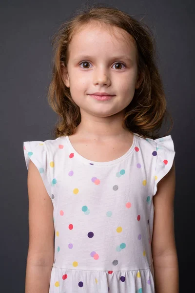 Мила молода дівчина з світлим волоссям на сірому фоні — стокове фото