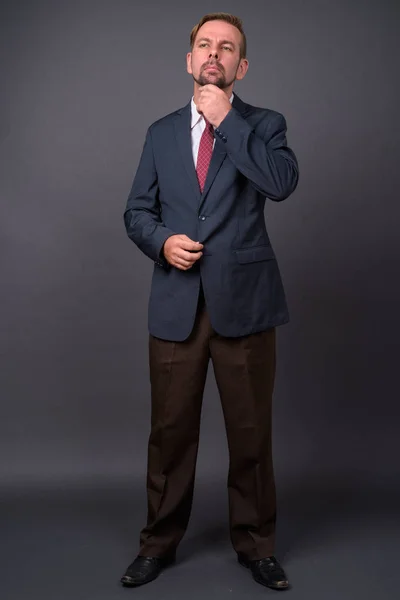 Hombre de negocios barbudo rubio con perilla sobre fondo gris —  Fotos de Stock