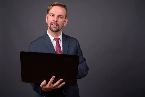 Blond bearded businessman with goatee against gray background — Stock Photo, Image