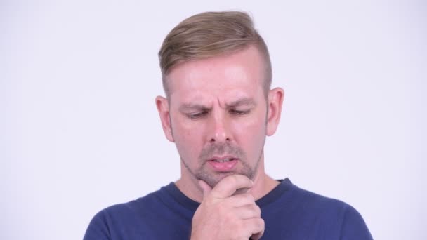 Porträt eines ernstzunehmenden blonden Mannes, der denkt und nach unten schaut — Stockvideo