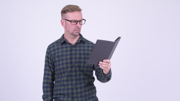 Irritado loira hipster homem ler livro com óculos — Vídeo de Stock