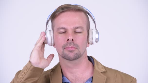 Feliz rubia casual hombre de negocios escuchando música — Vídeo de stock