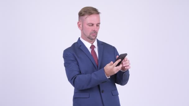 Šťastné blond podnikatel přemýšlet při používání telefonu — Stock video