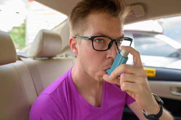 Προσώπου του ανθρώπου συσκευή εισπνοής άσθμα χρήση στο πίσω κάθισμα του αυτοκινήτου — Φωτογραφία Αρχείου