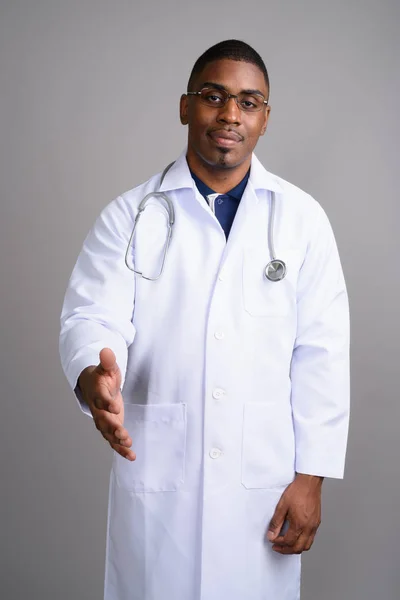 Jovem bonito Africano homem médico contra fundo cinza — Fotografia de Stock