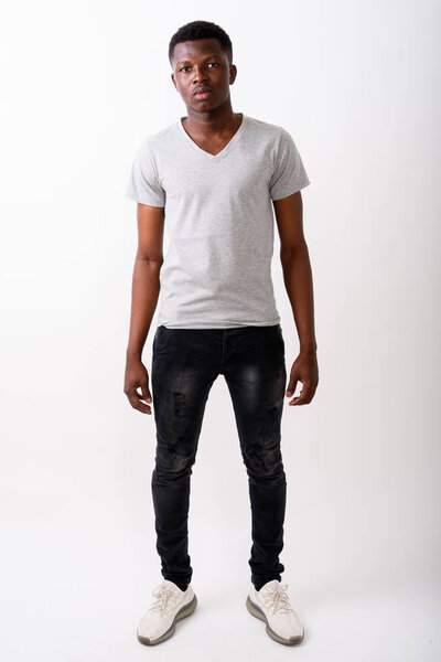 Full body shot of young black African man standing against white background