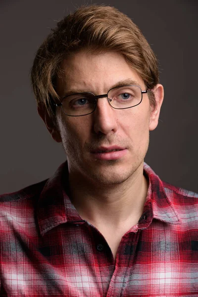 Hombre guapo usando anteojos contra fondo gris —  Fotos de Stock