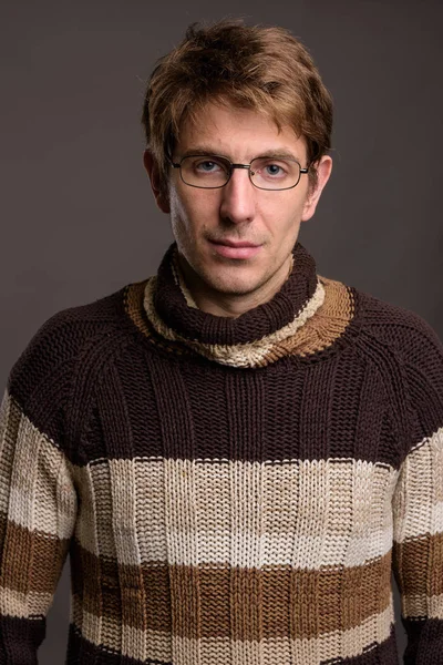 Pohledný muž nosí brýle proti šedé pozadí — Stock fotografie