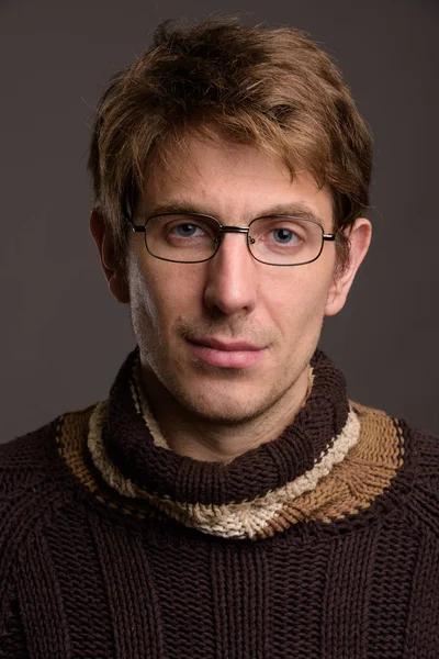 Hombre guapo usando anteojos contra fondo gris —  Fotos de Stock