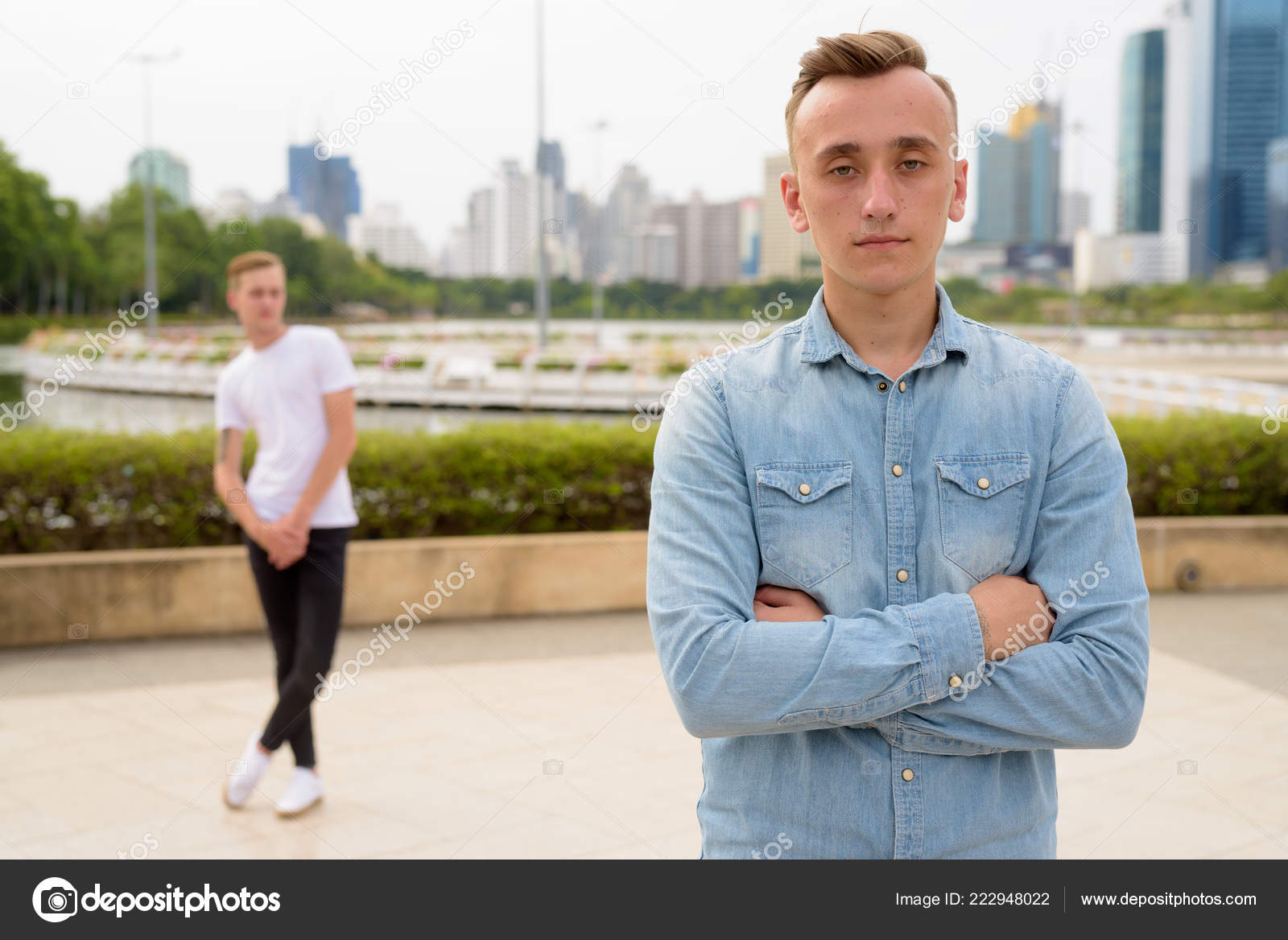 Two Young Handsome Men With Blond Hair Relaxing At The Park Toge