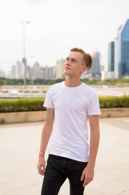 Bangkok, Tayland 'daki parkta dinlenen sarı saçlı yakışıklı bir adamın portresi.