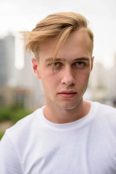 Tvář mladého pohledný muž s blond vlasy venku — Stock fotografie
