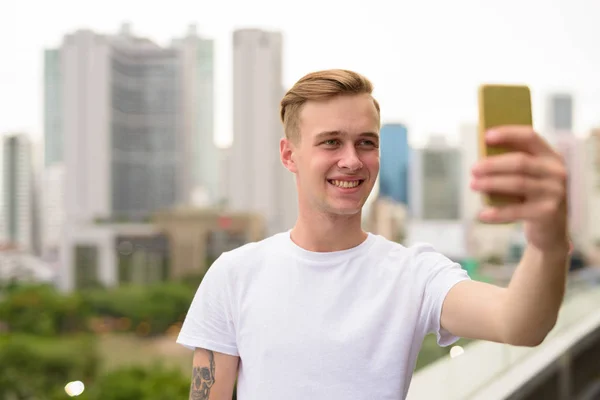 Young handsome man taking selfie with mobile phone — Stock Photo, Image