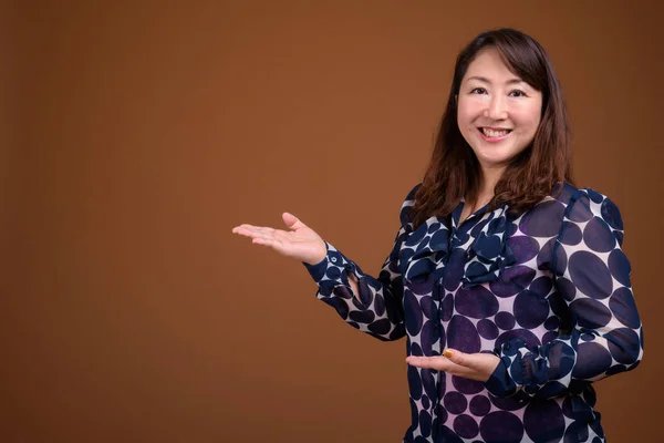 Madura hermosa mujer de negocios asiática contra fondo marrón —  Fotos de Stock