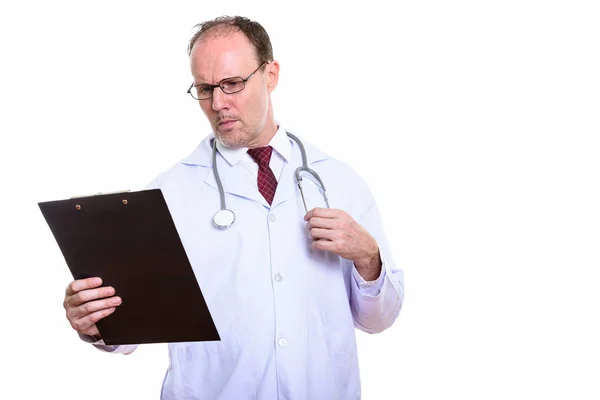 Studio shot of mature homme médecin lecture sur presse-papiers — Photo