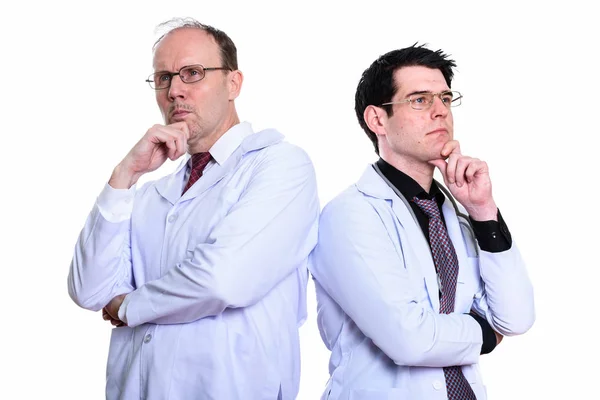 Älterer Mann Arzt und junger Mann Arzt denken zusammen — Stockfoto