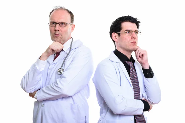 Mature man doctor and young man doctor thinking together — Stock Photo, Image