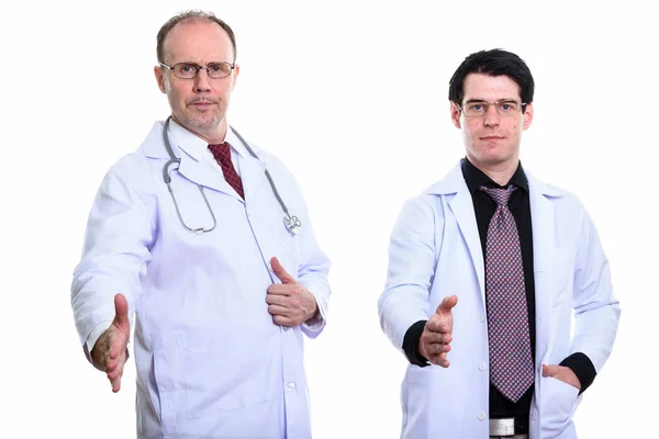 Dojrzały człowiek lekarz i lekarz młody człowiek razem dając uścisk dłoni — Zdjęcie stockowe