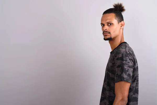 Young bearded handsome African man against gray background