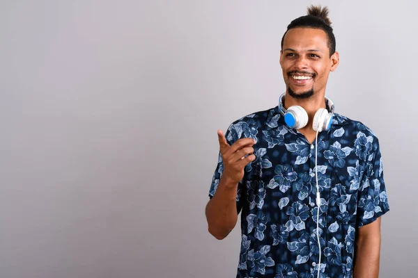 Jovem barbudo bonito homem africano usando fones de ouvido contra gr — Fotografia de Stock