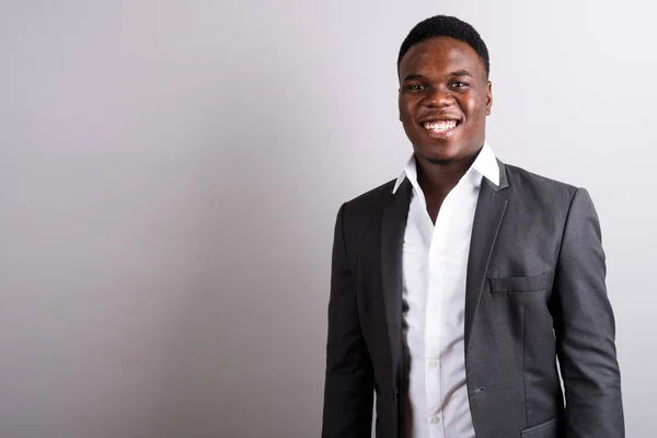 Jovem empresário africano vestindo terno contra fundo branco — Fotografia de Stock
