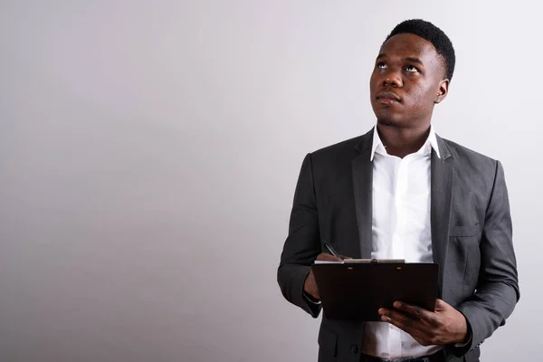 Jonge Afrikaanse zakenman draagt pak tegen witte achtergrond — Stockfoto