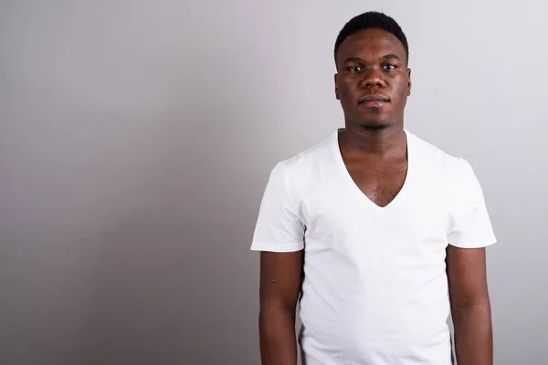 Portret van jonge Afrikaanse man tegen de witte achtergrond — Stockfoto