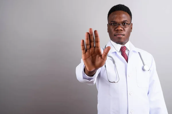 Young African man doctor against white background — Stock Photo, Image