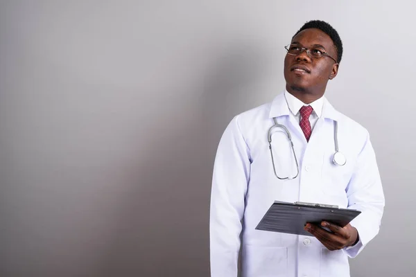Young African man doctor against white background — Stock Photo, Image