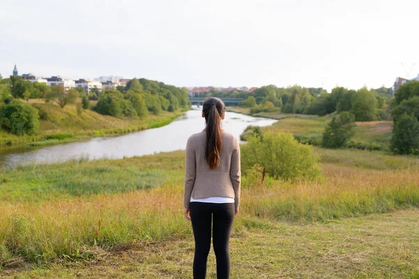 Weergave van jonge Aziatische vrouw tegen ontspannen aan de achterkant uitzicht op natuur — Stockfoto