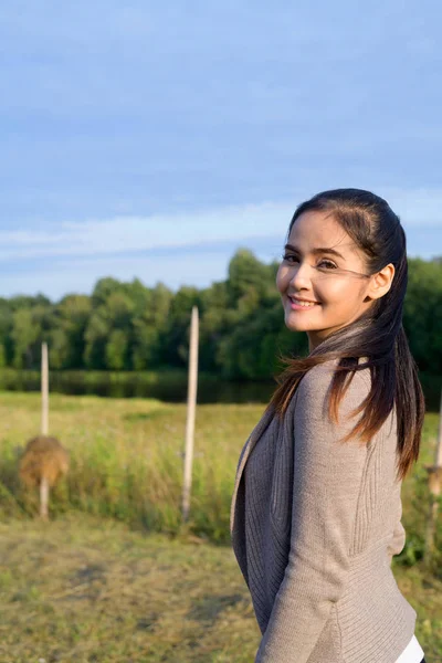 Jovem mulher asiática feliz sorrindo contra a visão relaxante da natureza — Fotografia de Stock