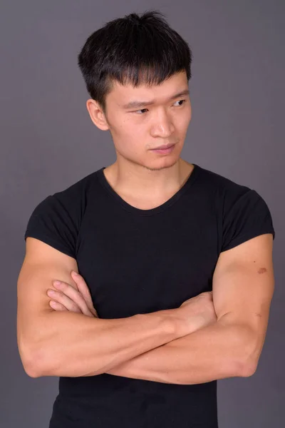 Estúdio tiro de jovem chinês contra fundo cinza — Fotografia de Stock