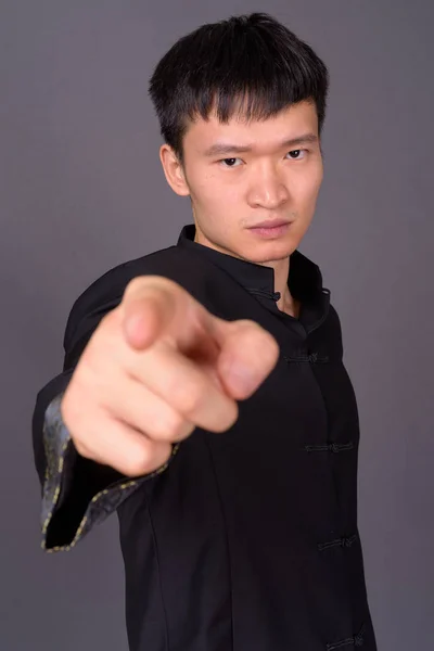 Студийный снимок молодого китайца на сером фоне — стоковое фото