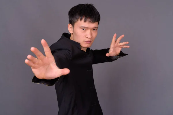 Stúdió lövés fiatal kínai férfi szürke háttér — Stock Fotó