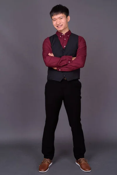 Retrato de joven empresario chino sobre fondo gris — Foto de Stock