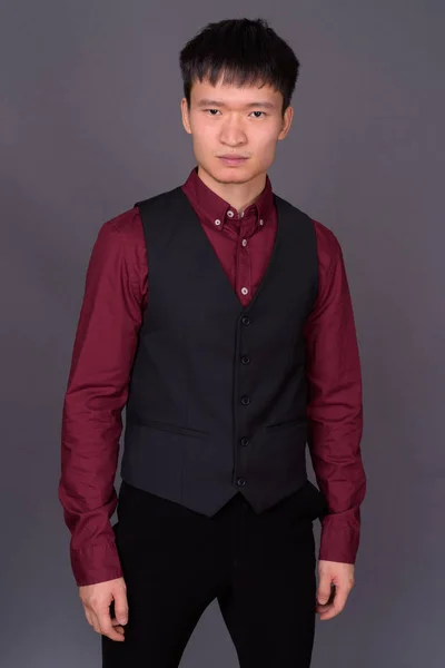 Retrato de jovem empresário chinês contra fundo cinza — Fotografia de Stock