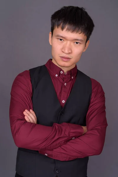 Портрет молодого китайского бизнесмена на сером фоне — стоковое фото