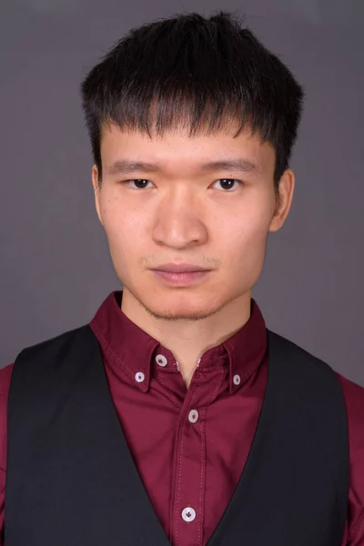 Портрет молодий китайський бізнесмена проти сірий фон — стокове фото