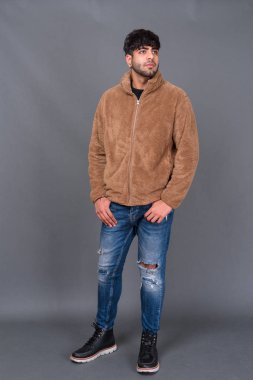 Gri arka planda genç ve yakışıklı bir Hintli.