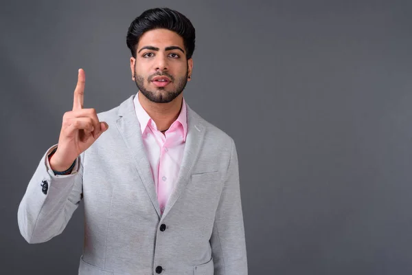 Joven guapo empresario indio contra fondo gris —  Fotos de Stock