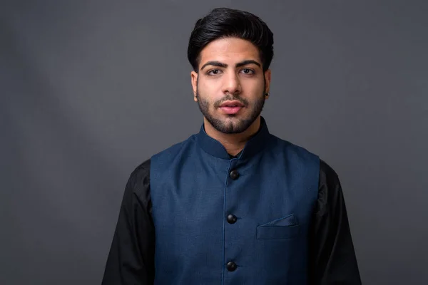 Jovem bonito empresário indiano contra fundo cinza — Fotografia de Stock