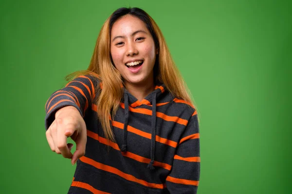 Porträtt av ung asiatisk kvinna mot grön bakgrund — Stockfoto