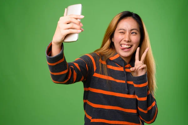 緑の背景に対して若いアジア女性の肖像画 — ストック写真