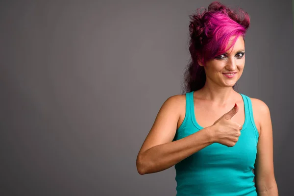 Bella donna con i capelli rosa e make-up contro backgrou grigio — Foto Stock