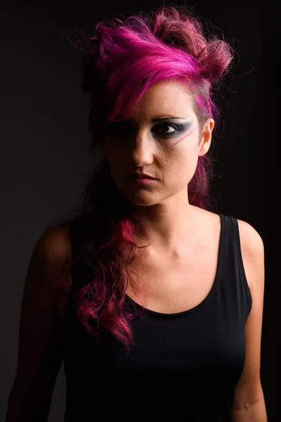 Hermosa mujer con pelo rosa y maquillaje contra el fondo gris — Foto de Stock
