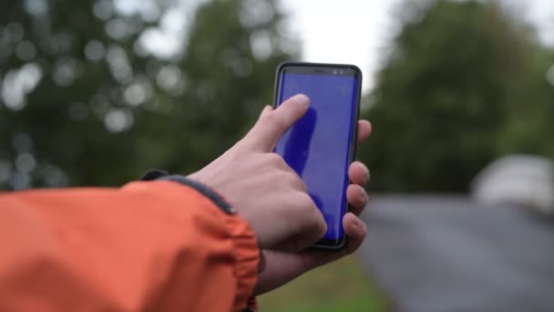 携帯電話を屋外で使う若い男の手 — ストック動画
