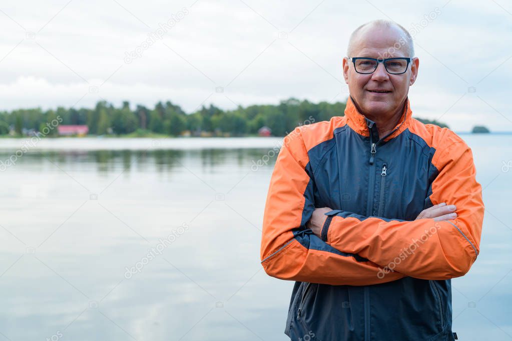 Portrait Of Happy Senior Man Smiling By The Lake