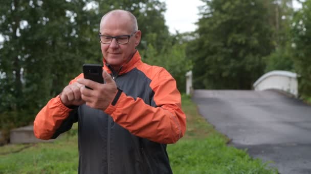 Gelukkig Senior Man buitenshuis gebruik van telefoon — Stockvideo