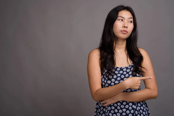 Asiatico donna indossare blu abito contro grigio sfondo — Foto Stock